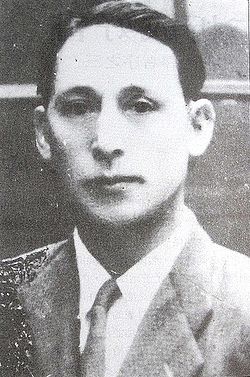 Young man in a suit and tie posing for a formal portrait in black and white.