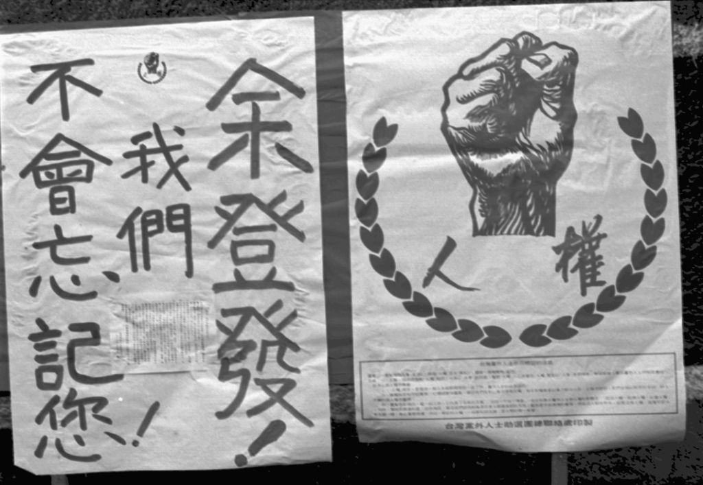 Two black-and-white posters: the left one has vertical Asian script, the right one features a raised clenched fist inside a laurel wreath with blocks of text beneath.