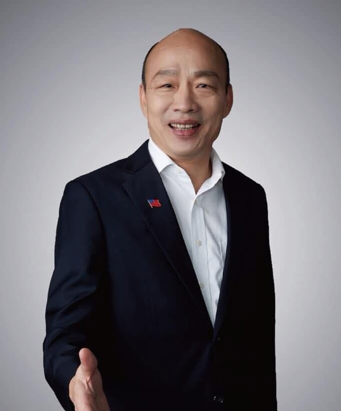 Asian man in a light blue button-down shirt looking at the camera with a neutral expression.